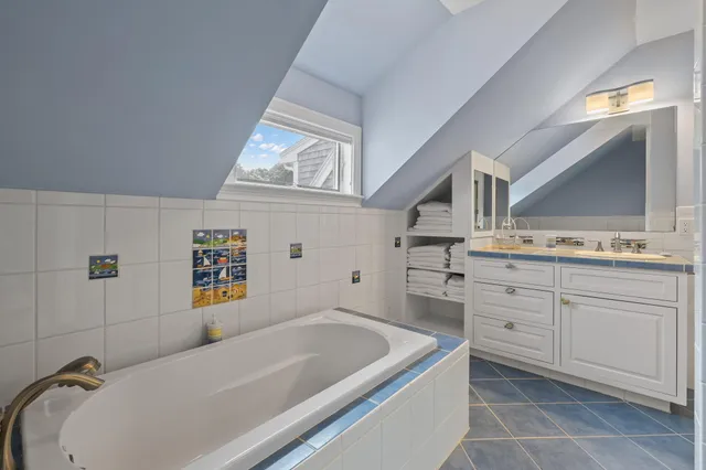 a bathroom with a tub sink and mirror