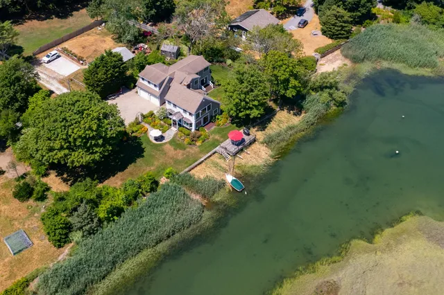 an aerial view of residential houses with outdoor space and lake view