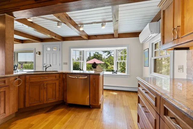 a large room with wooden floors and stainless steel appliances
