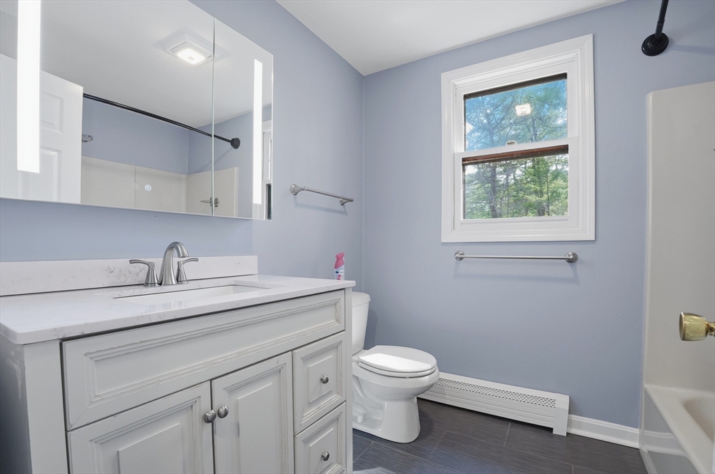 30 Packet Landing, Unit A Pembroke, MA 02359 - Photo 17 of 32 a bathroom with a granite countertop toilet sink and mirror