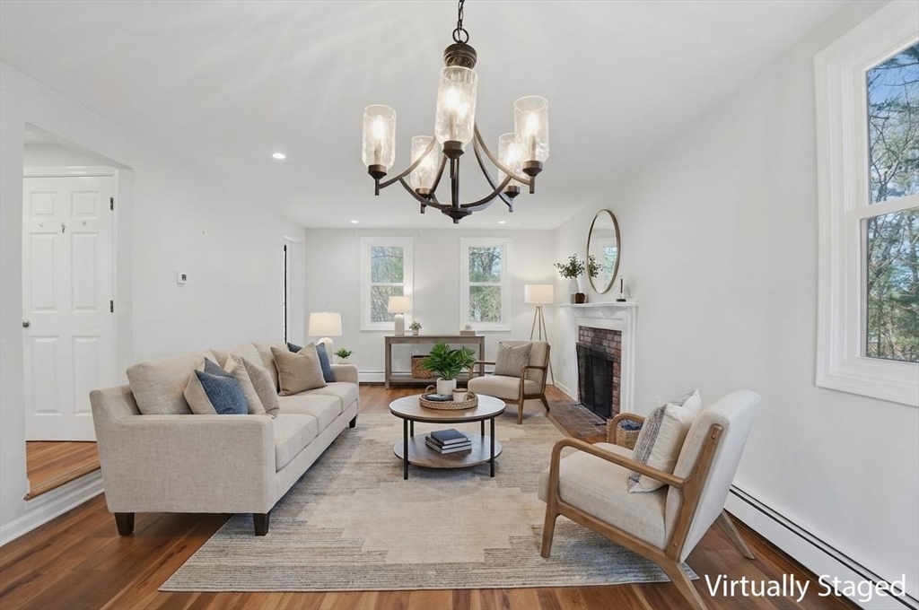 30 Packet Landing, Unit A Pembroke, MA 02359 - Photo 3 of 32 a living room with furniture a fireplace and a chandelier