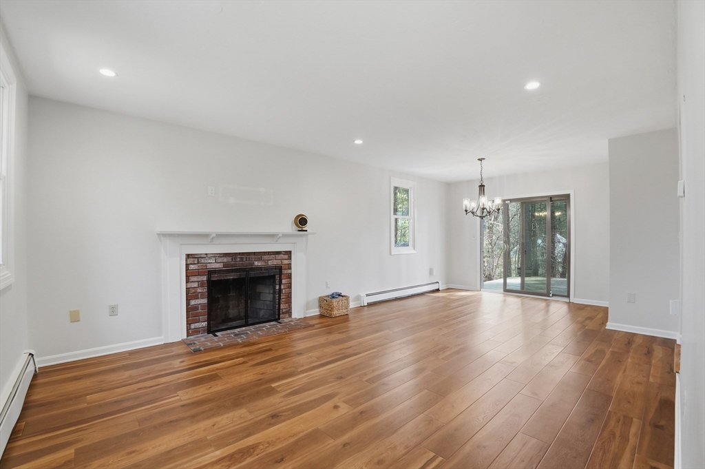 30 Packet Landing, Unit A Pembroke, MA 02359 - Photo 7 of 32 an empty room with wooden floor fireplace and windows