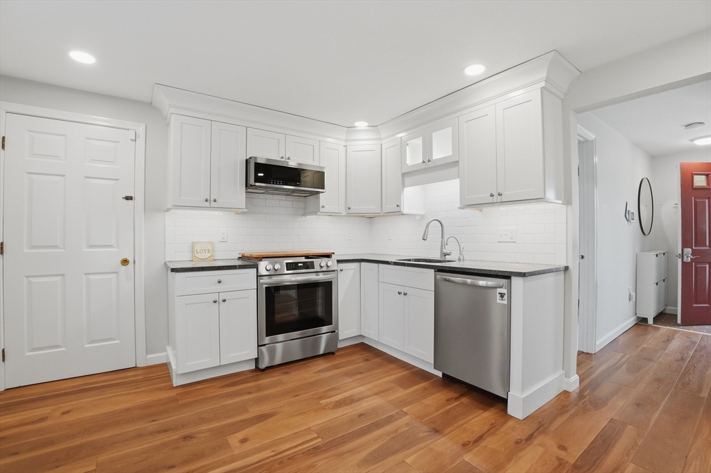 30 Packet Landing, Unit A Pembroke, MA 02359 - Photo 8 of 32 a kitchen with stainless steel appliances granite countertop a sink stove and refrigerator
