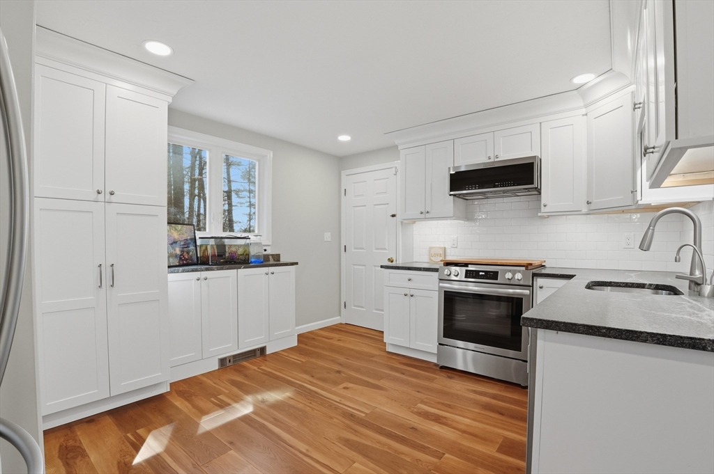 30 Packet Landing, Unit A Pembroke, MA 02359 - Photo 9 of 32 a kitchen with stainless steel appliances granite countertop a stove a sink and a refrigerator