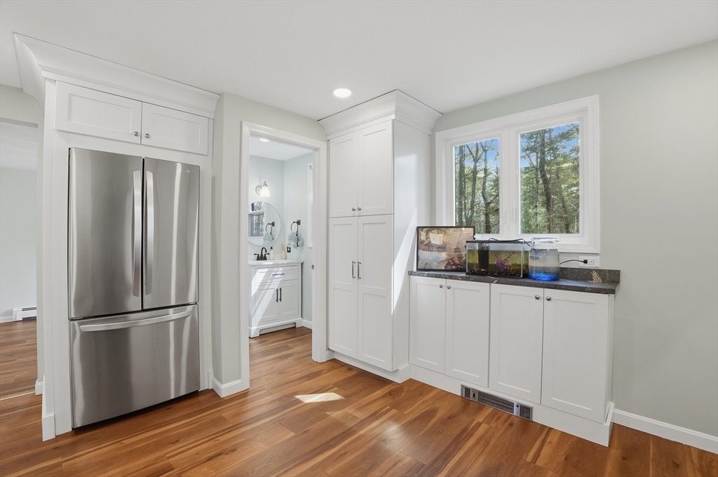 30 Packet Landing, Unit A Pembroke, MA 02359 - Photo 10 of 32 a kitchen with white cabinets and wooden floor