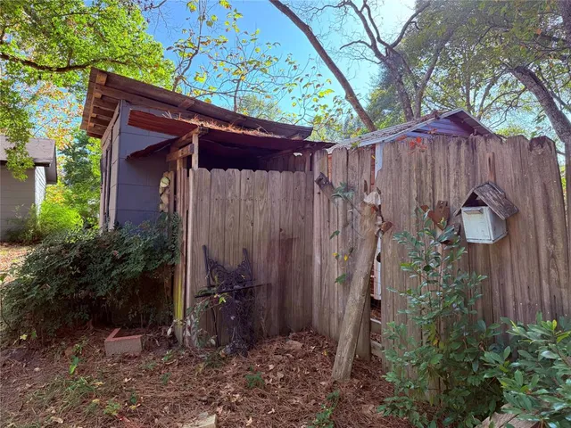 a view of a house with a backyard and trees