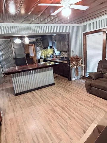 a kitchen with stainless steel appliances kitchen island granite countertop lots of wooden cabinets a stove and a sink