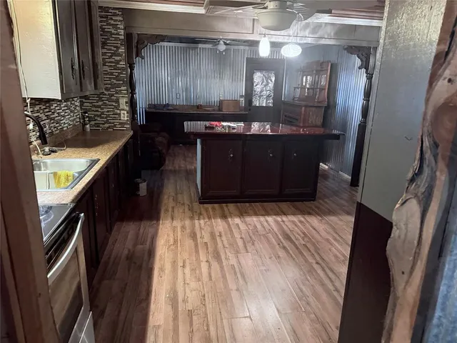 a kitchen with a sink and wooden floor