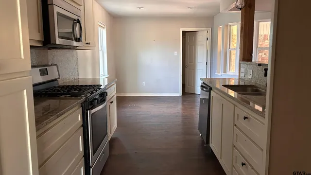 a kitchen with stainless steel appliances granite countertop a stove and a refrigerator