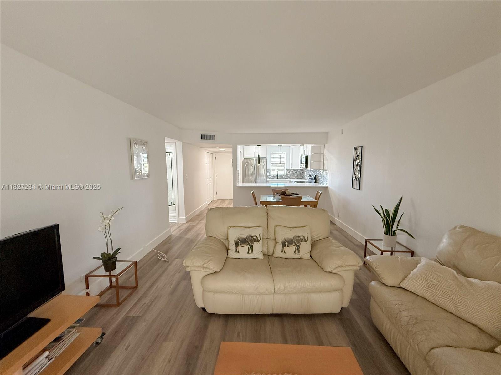 9355 Southwest 8th Street, Unit 402 Boca Raton, FL 33428 - Photo 15 of 29 a living room with furniture and a flat screen tv