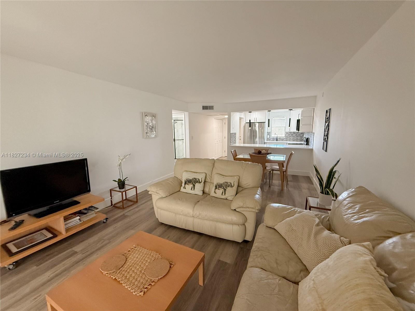 9355 Southwest 8th Street, Unit 402 Boca Raton, FL 33428 - Photo 16 of 29 a living room with furniture and a flat screen tv