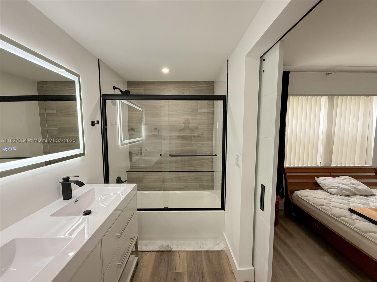 9355 Southwest 8th Street, Unit 402 Boca Raton, FL 33428 - Photo 20 of 29 a bathroom with a tub sink and mirror