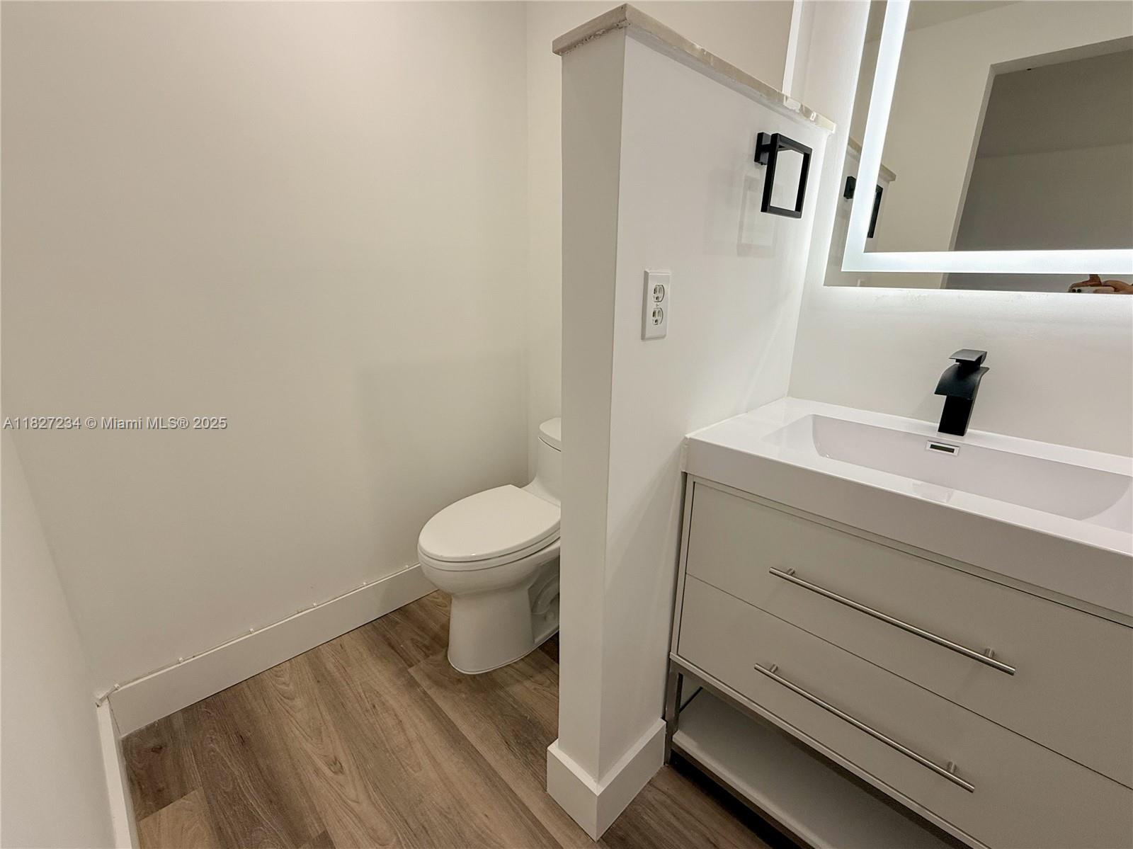 9355 Southwest 8th Street, Unit 402 Boca Raton, FL 33428 - Photo 22 of 29 a bathroom with a sink a toilet and a mirror