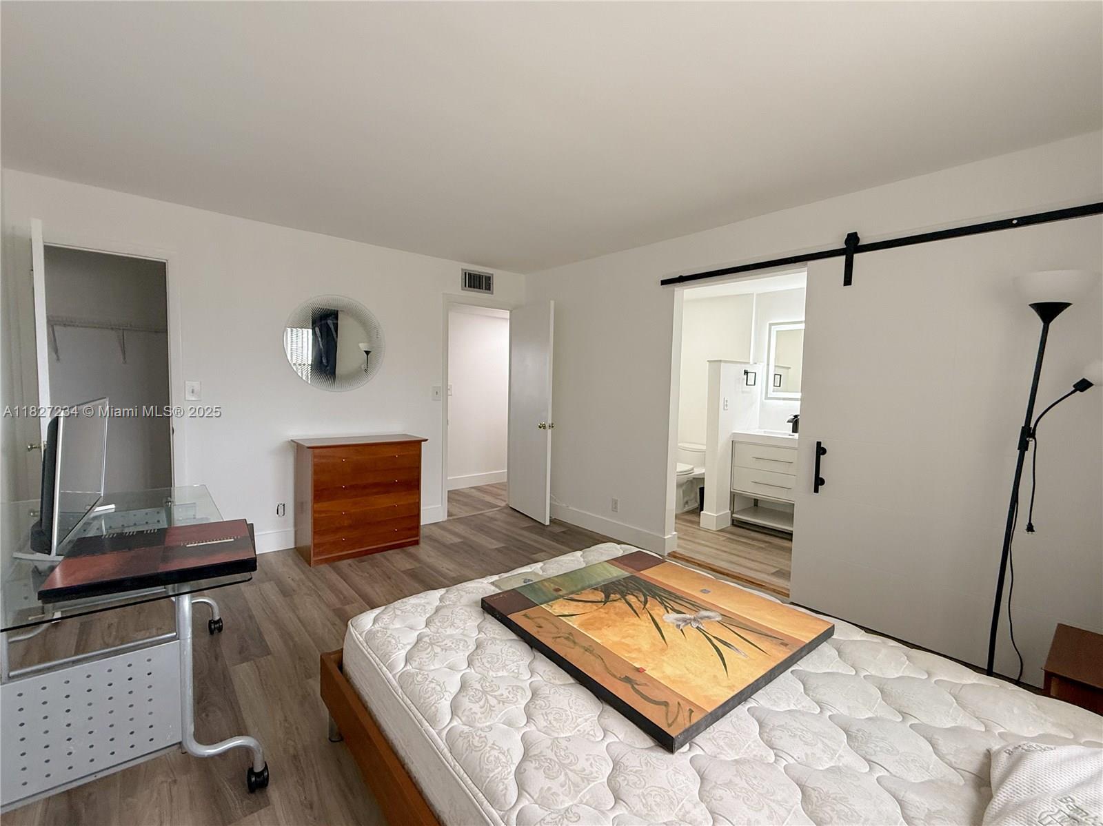 9355 Southwest 8th Street, Unit 402 Boca Raton, FL 33428 - Photo 23 of 29 a bedroom with a bed and a flat screen tv