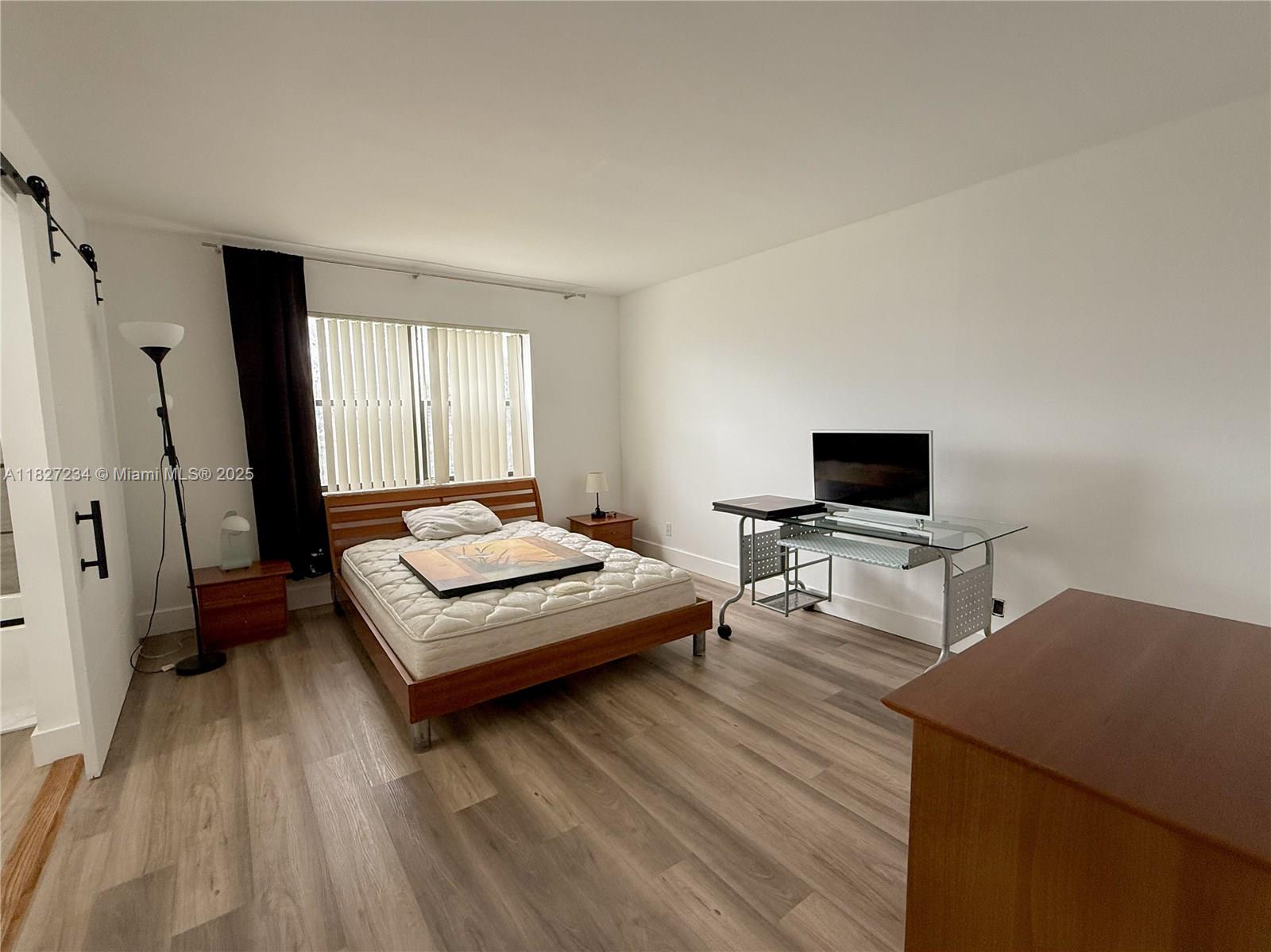 9355 Southwest 8th Street, Unit 402 Boca Raton, FL 33428 - Photo 24 of 29 a bedroom with a bed and a flat screen tv