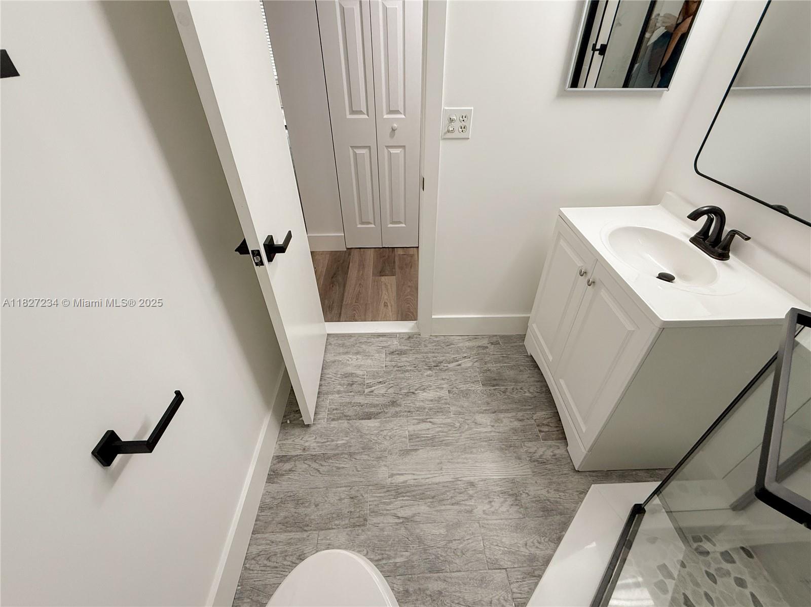 9355 Southwest 8th Street, Unit 402 Boca Raton, FL 33428 - Photo 26 of 29 a bathroom with a sink a mirror and shower