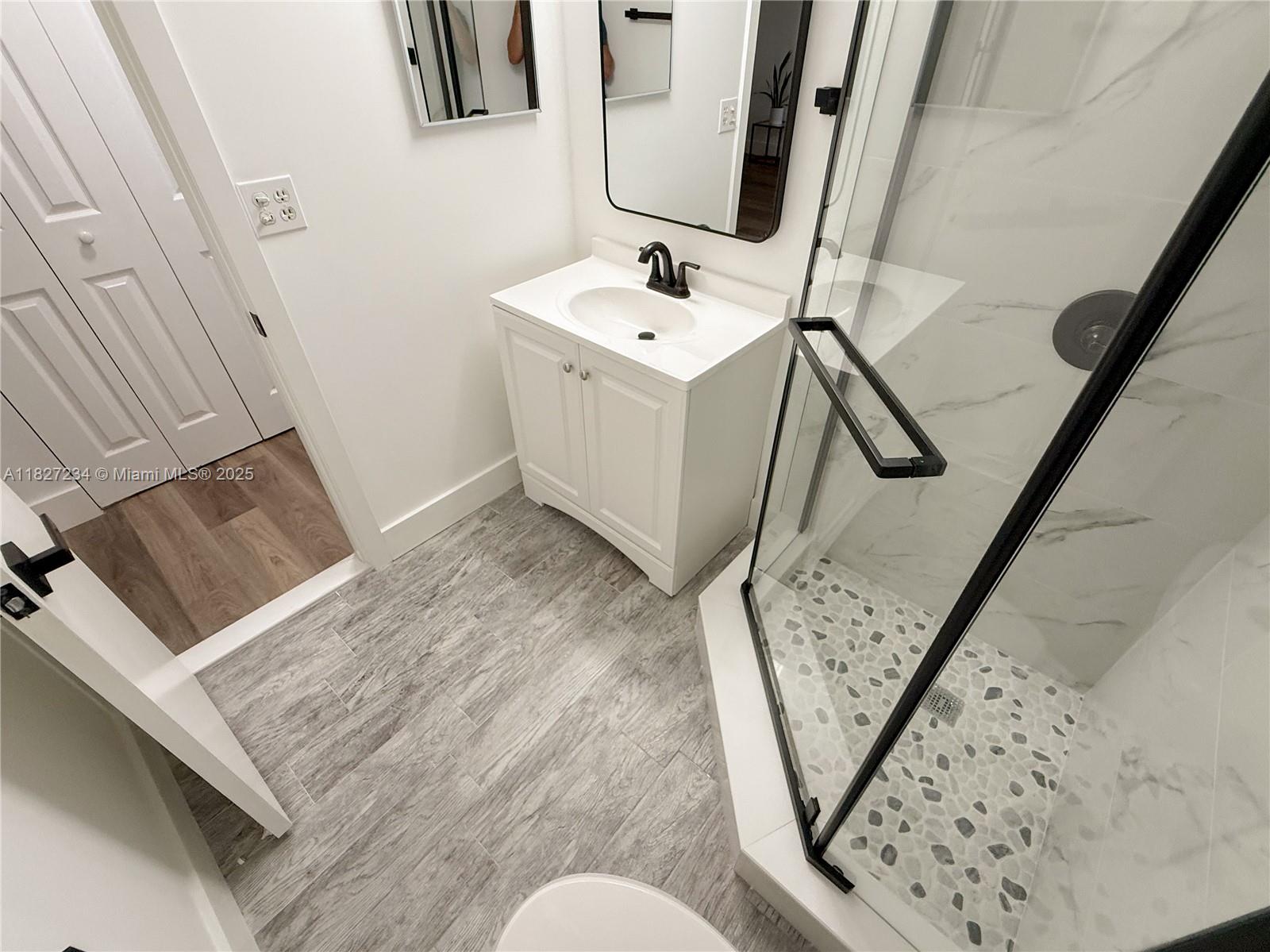 9355 Southwest 8th Street, Unit 402 Boca Raton, FL 33428 - Photo 27 of 29 a bathroom with a sink mirror and vanity