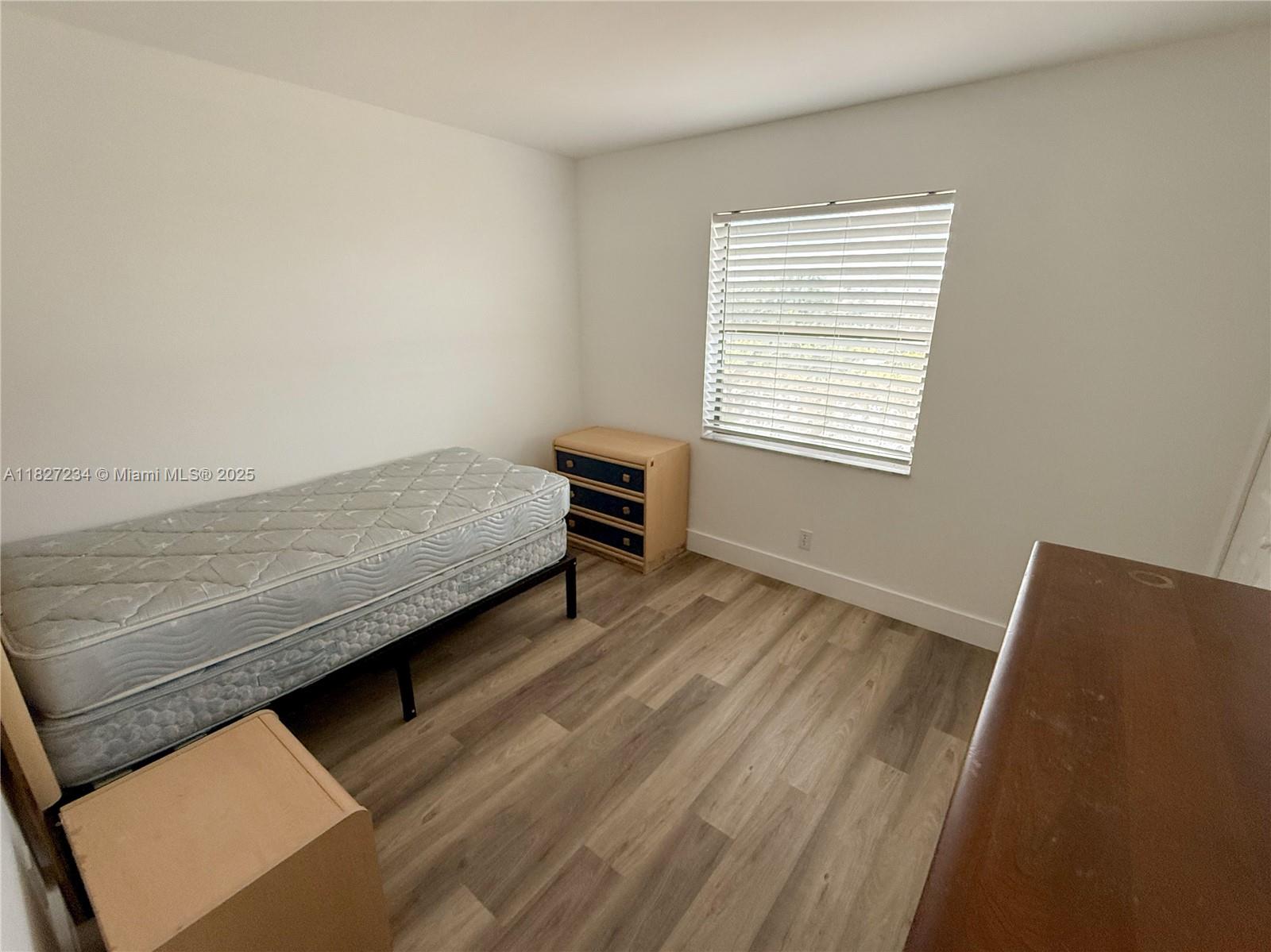 9355 Southwest 8th Street, Unit 402 Boca Raton, FL 33428 - Photo 28 of 29 a bedroom with a bed and a chair