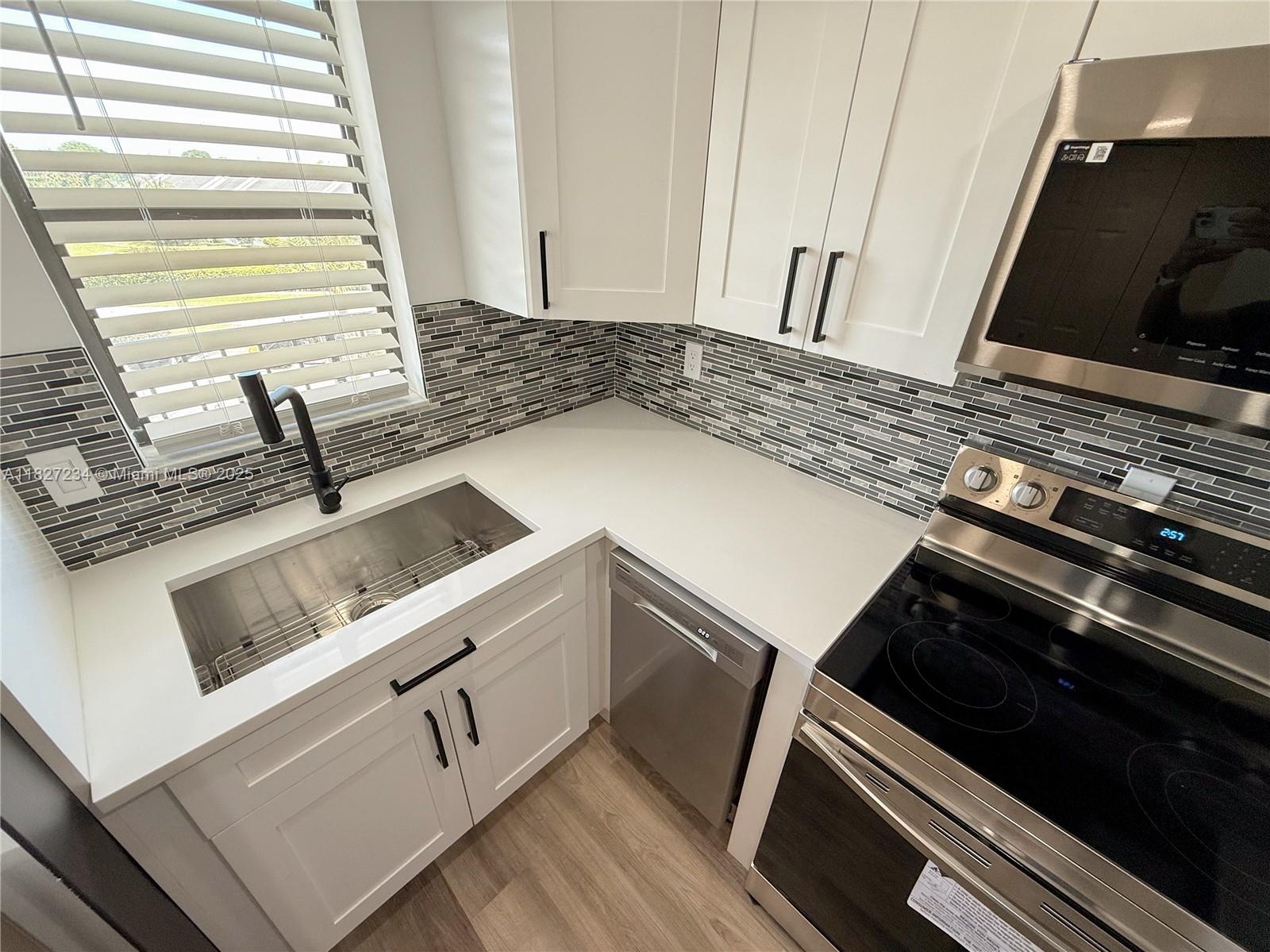 9355 Southwest 8th Street, Unit 402 Boca Raton, FL 33428 - Photo 8 of 29 a kitchen with sink and cabinets