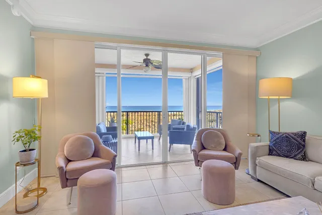 a living room with furniture a lamp and a large window