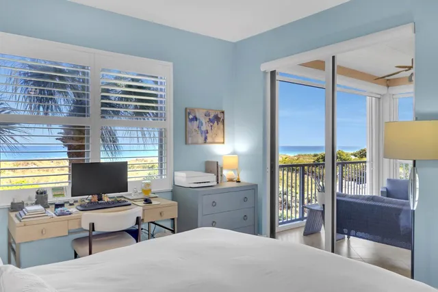 a bedroom with a bed and large windows