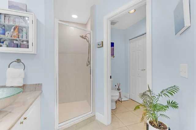 a bathroom with a granite countertop sink a toilet and shower