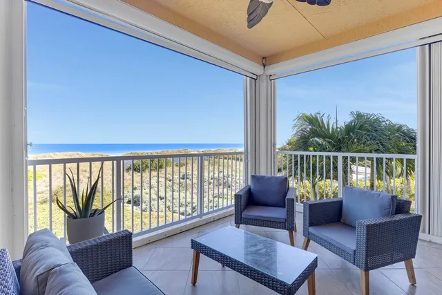 a living room with furniture and a floor to ceiling window