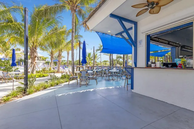 a view of a patio with a table and chairs under an umbrella