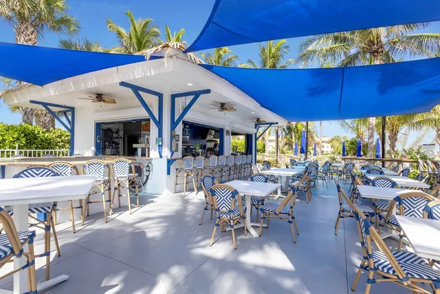 a view of a patio with table and chairs under an umbrella