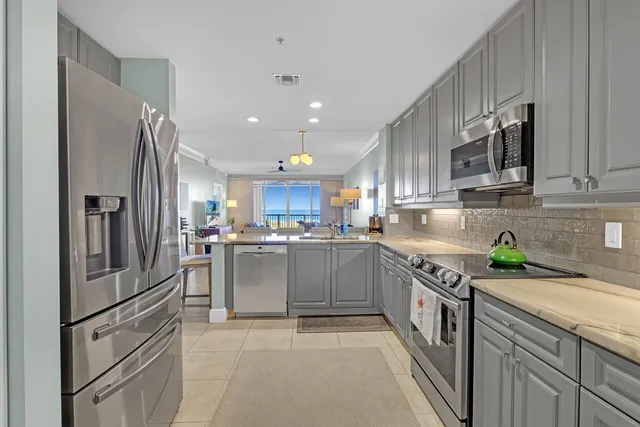 a kitchen with granite countertop a refrigerator stove top oven and sink