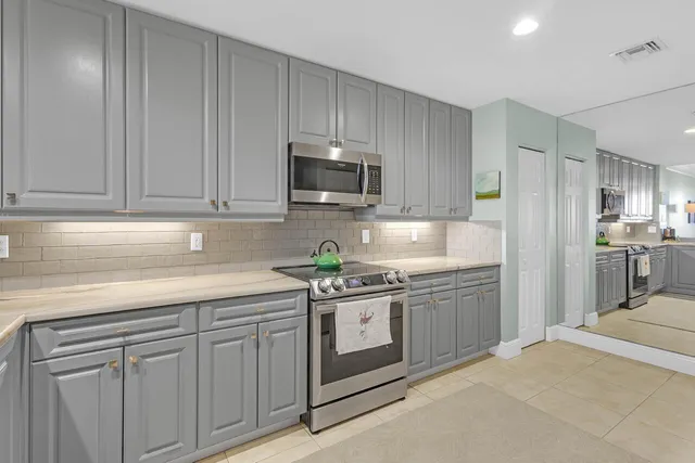 a kitchen with stainless steel appliances granite countertop a stove a sink and a microwave