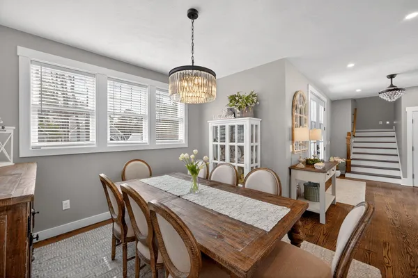 a kitchen with stainless steel appliances granite countertop a refrigerator a sink a stove and white cabinets with wooden floor