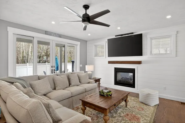 a living room with furniture a fireplace and a flat screen tv