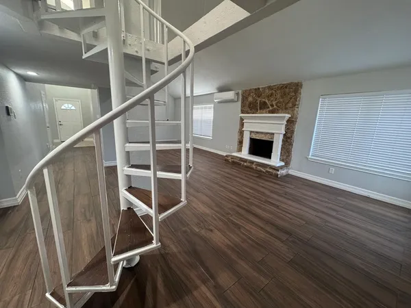 a view of a livingroom with wooden floor and fireplace