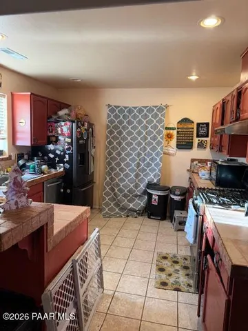 a kitchen with stainless steel appliances kitchen island granite countertop a stove a sink and a microwave