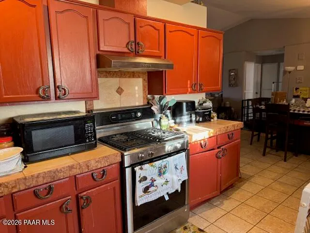a kitchen with stainless steel appliances granite countertop a stove and a microwave