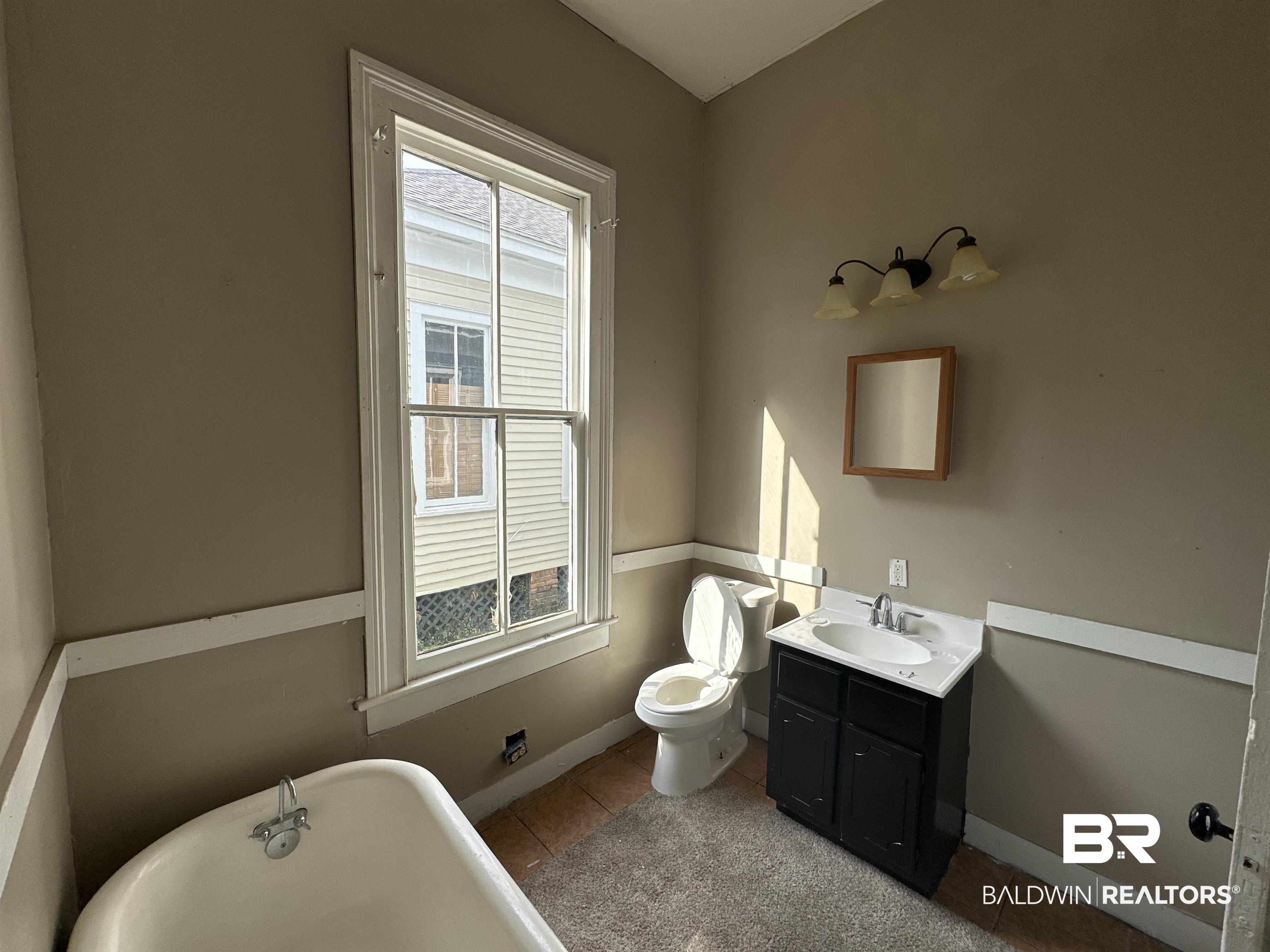 1119 Old Shell Road Mobile, AL 36604 - Photo 12 of 22 Bathroom with vanity, a bath, tile patterned floors, and toilet