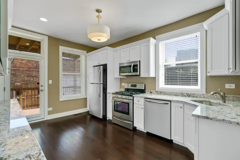 a kitchen with granite countertop stainless steel appliances a refrigerator stove and microwave