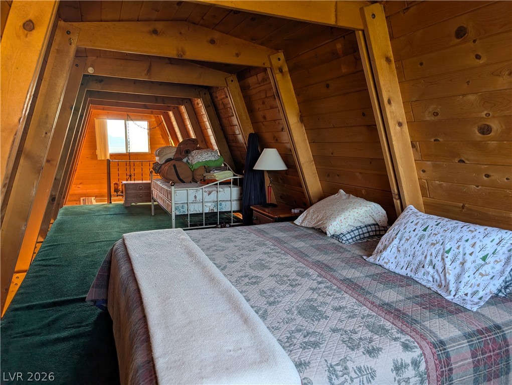 20502 Windsong Road Pioche, NV 89043 - Photo 10 of 30 Warm wood paneling wraps this cozy A-frame loft bedroom with rustic architectural charm.