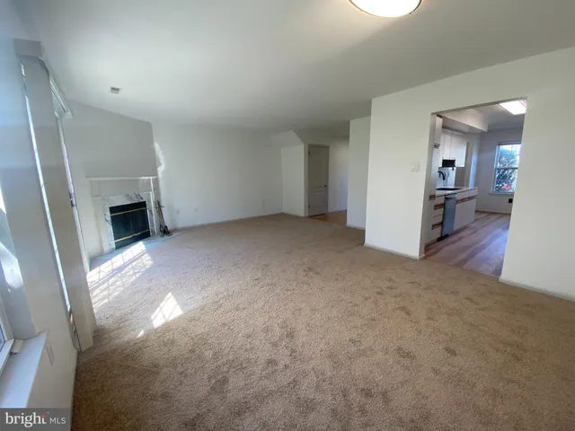an empty room with fireplace and wooden floor