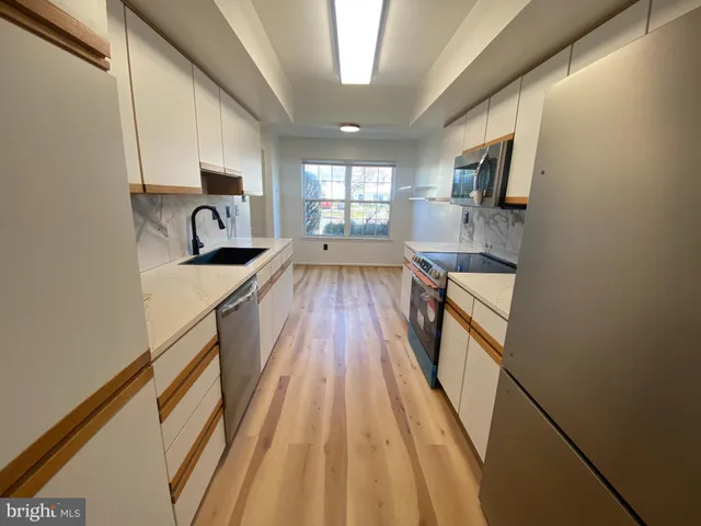 a view of a kitchen with a sink and wooden floor