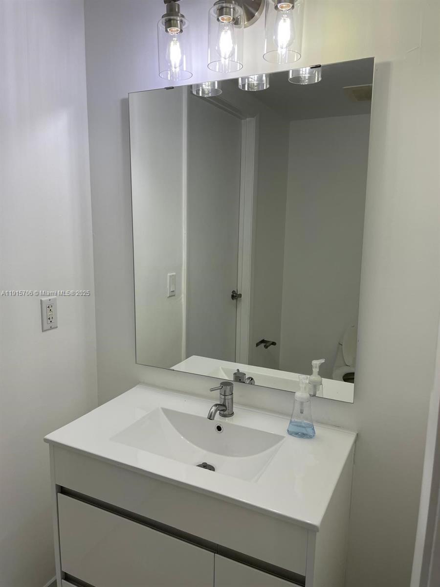 92 Southwest 3rd Street, Unit 3309 Miami, FL 33130 - Photo 6 of 7 a bathroom with a sink and a mirror