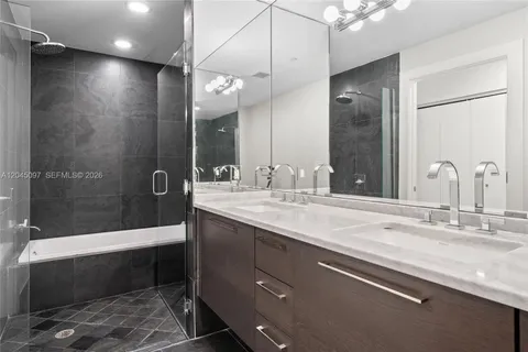 a bathroom with a sink a toilet a mirror and bathtub