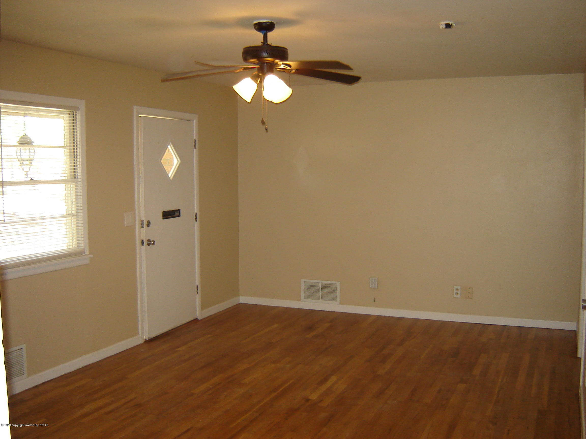 4013 Crockett Street Amarillo, TX 79110 - Photo 4 of 28 an empty room with wooden floor mirror and windows
