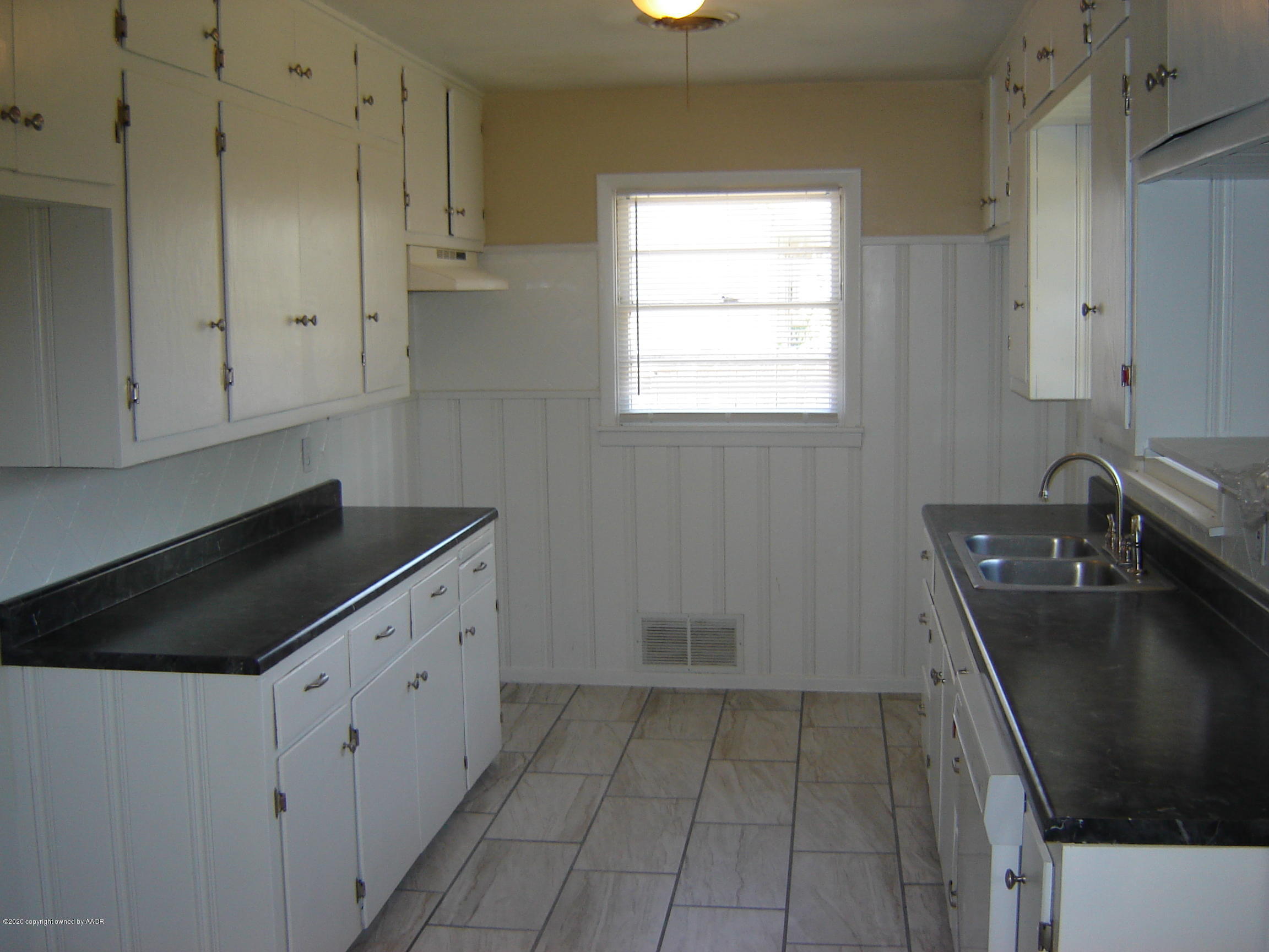 4013 Crockett Street Amarillo, TX 79110 - Photo 8 of 28 a kitchen with a sink a stove and cabinets