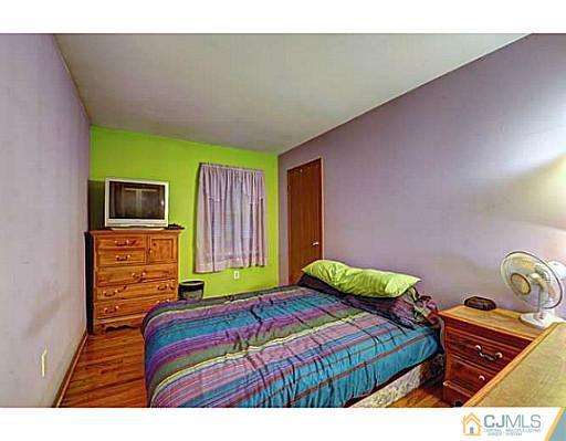 119 Dover Road Colonia, NJ 07067 - Photo 14 of 25 a bedroom with a bed and flat screen tv