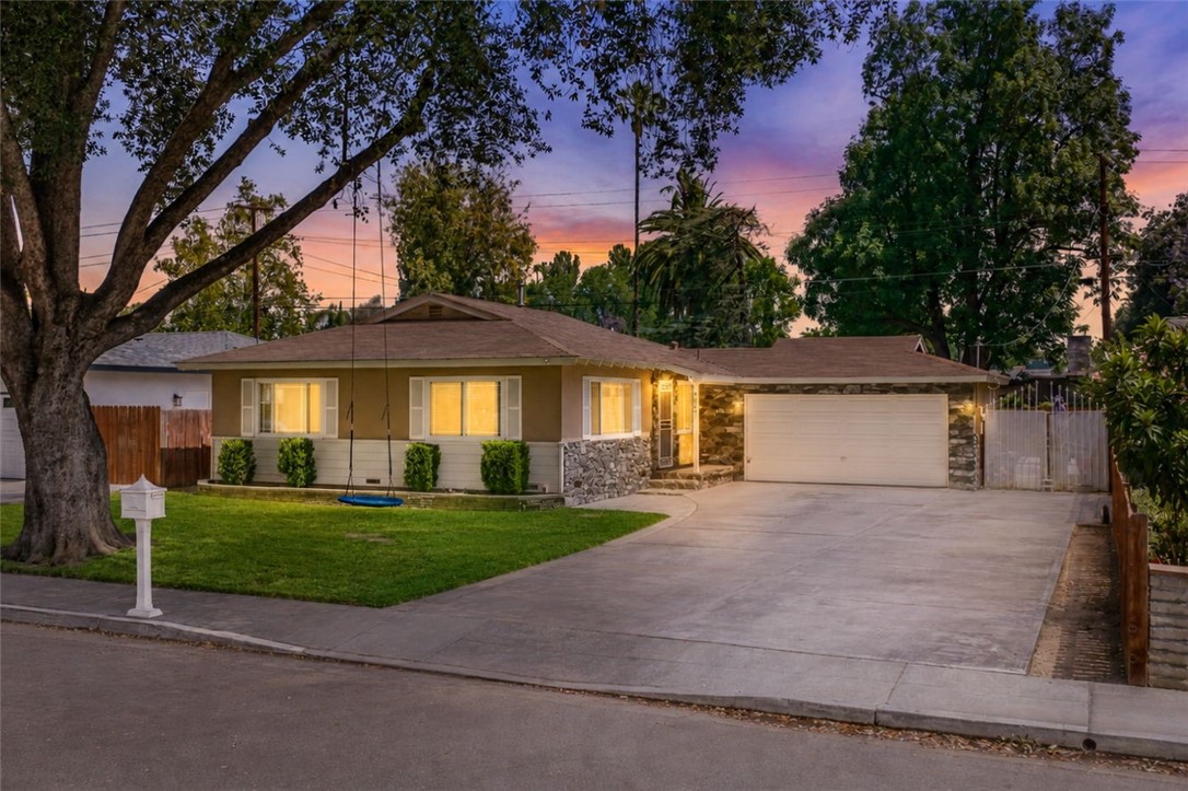 4869 Serrano Place Riverside, CA 92504 - Photo 1 of 40 Beautiful evening exterior showcasing warm window light, spacious parking, and a peaceful neighborhood setting.