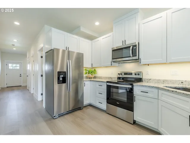 a kitchen with stainless steel appliances a refrigerator stove and microwave