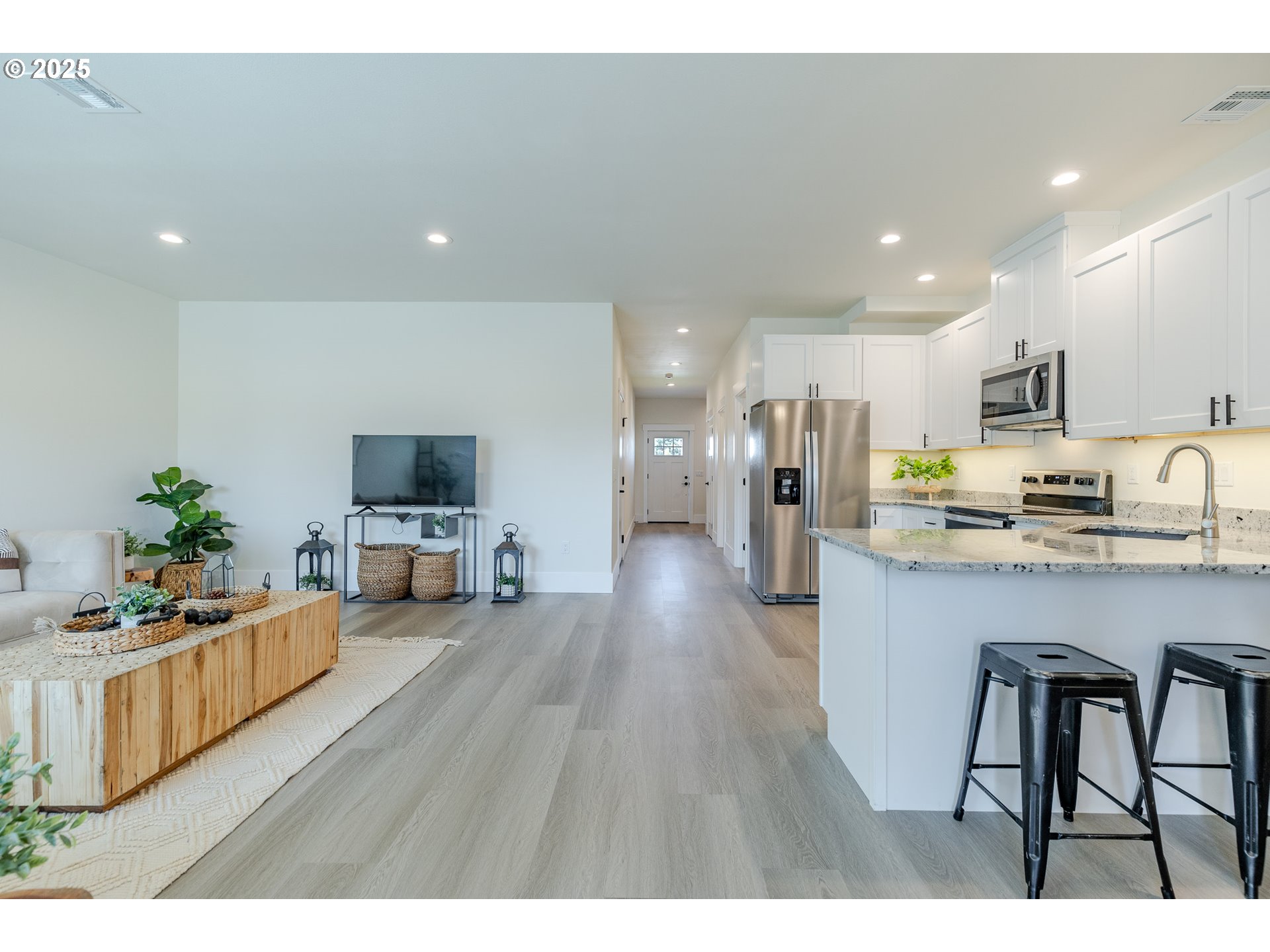 729 Periander Way Harrisburg, OR 97446 - Photo 7 of 24 a living room with furniture a flat screen tv and kitchen view