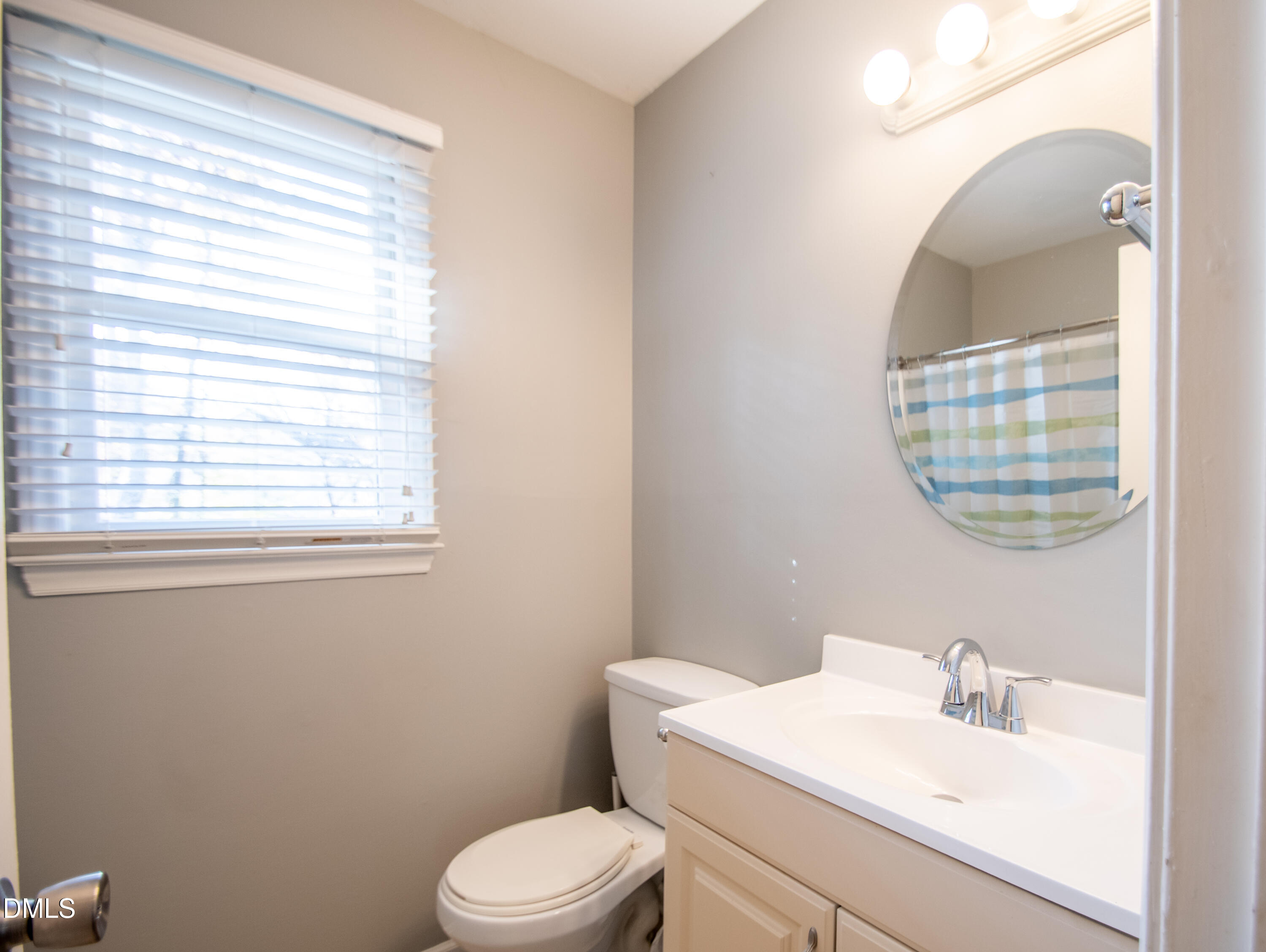 4700 Draper Road Raleigh, NC 27616 - Photo 23 of 31 a bathroom with a toilet a sink and a mirror